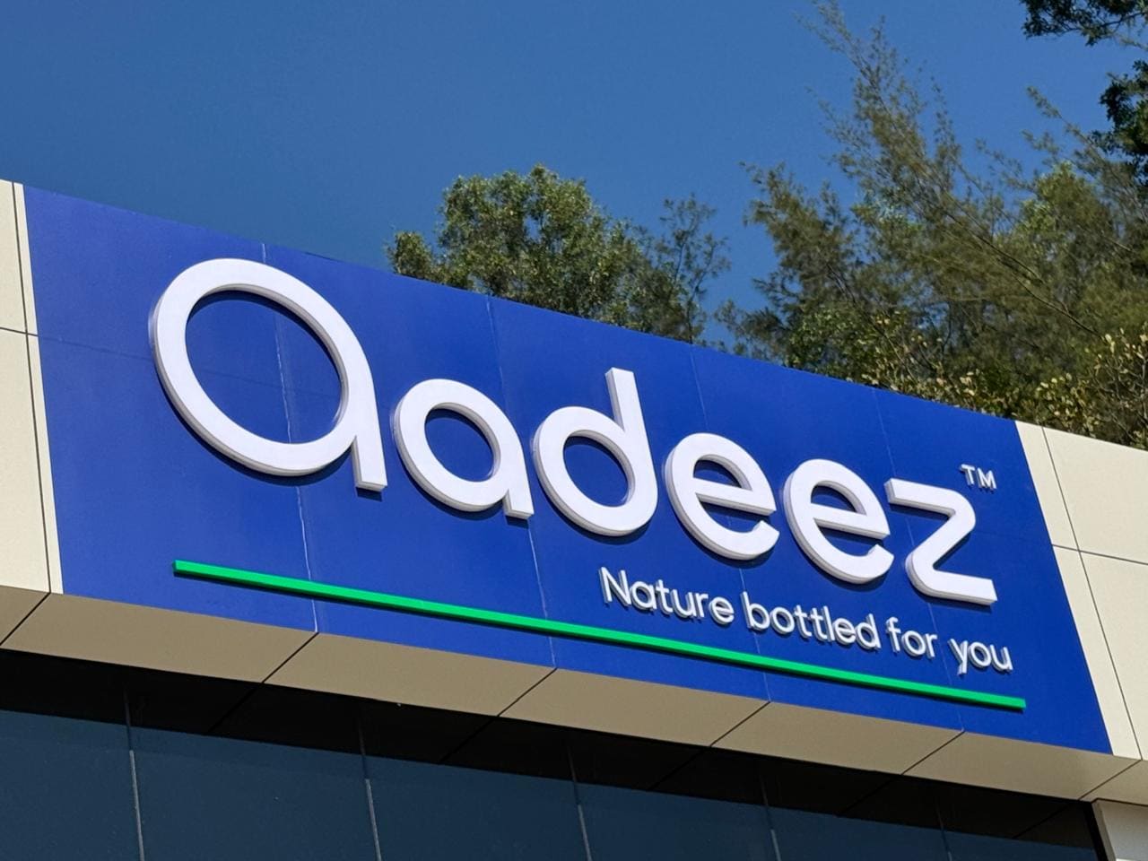 An angled view of the Aadeez fascia sign and facility exterior.