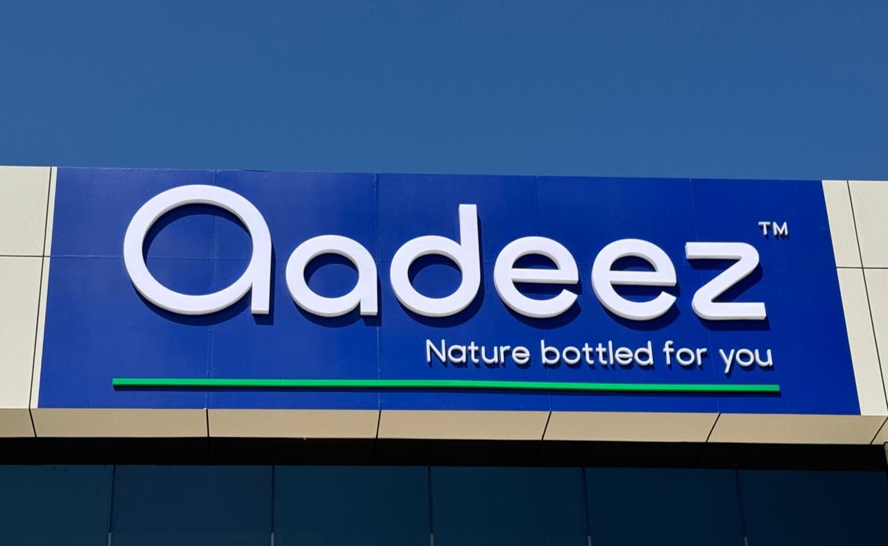 The Aadeez fascia sign on the facility: white lettering on a blue field with a green rule and the tagline.