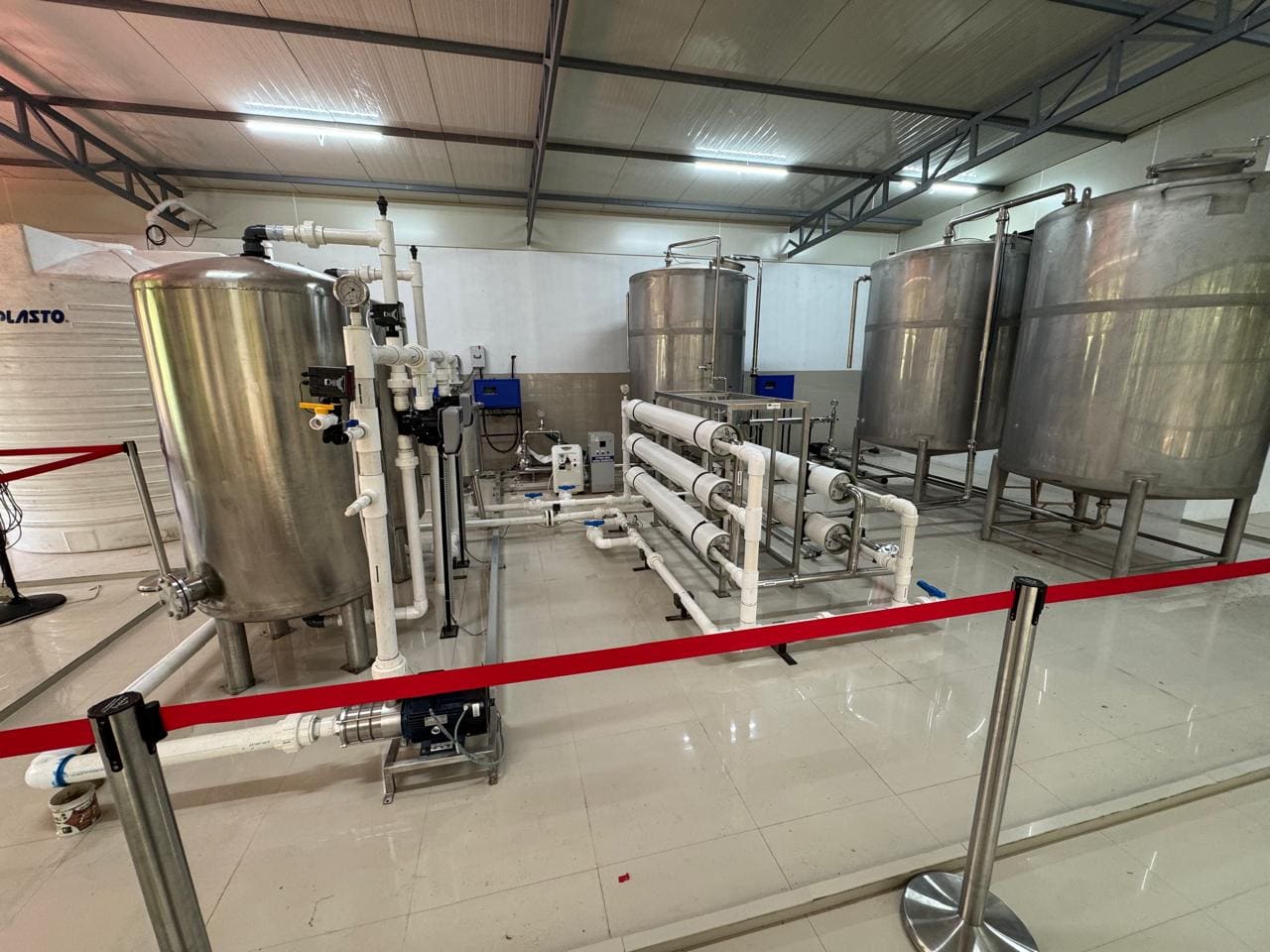 A rack of horizontal white pressure vessels with connecting pipework inside the treatment hall.