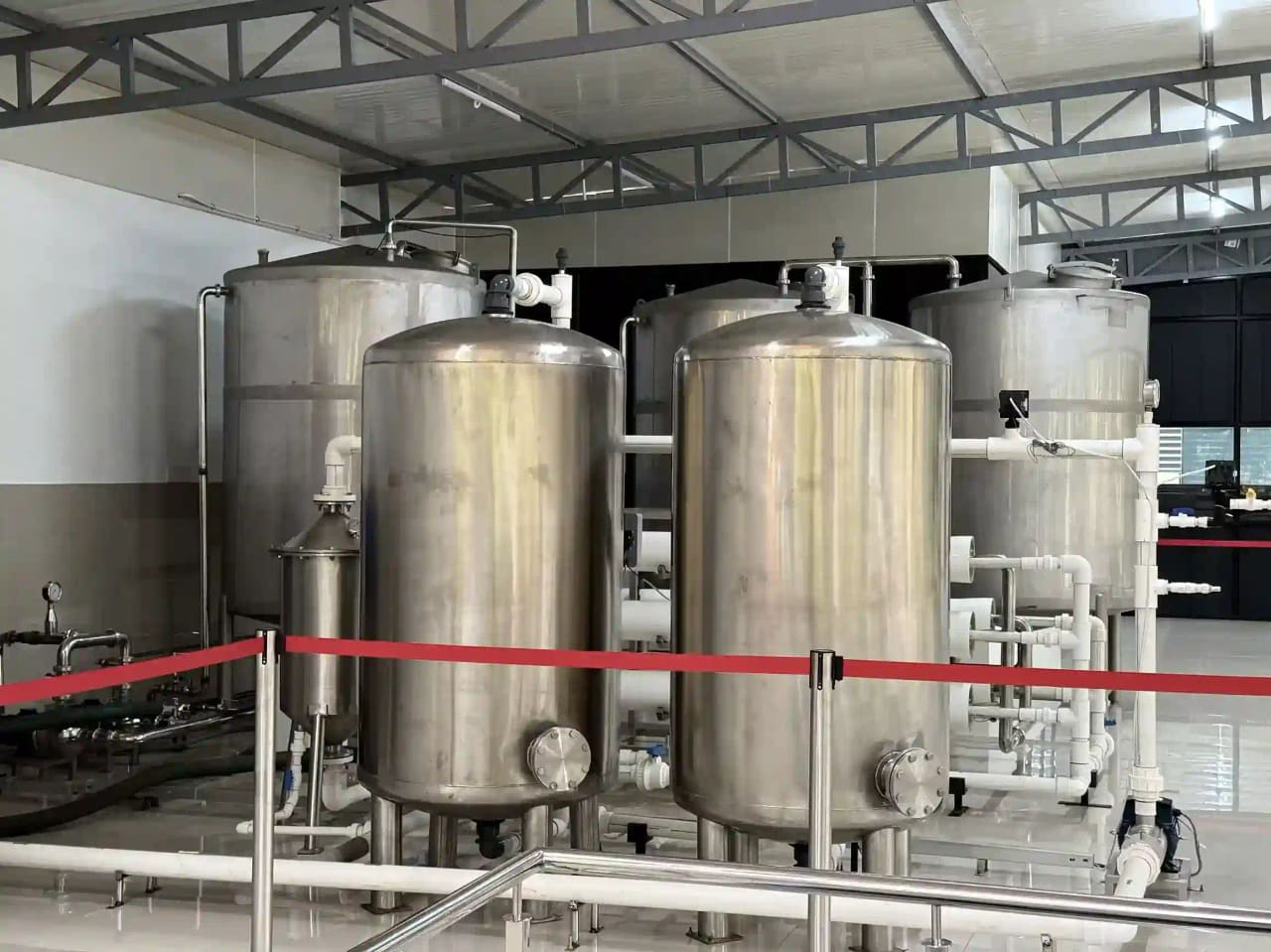 A rack of horizontal white pressure vessels with connecting pipework inside the filtration hall.